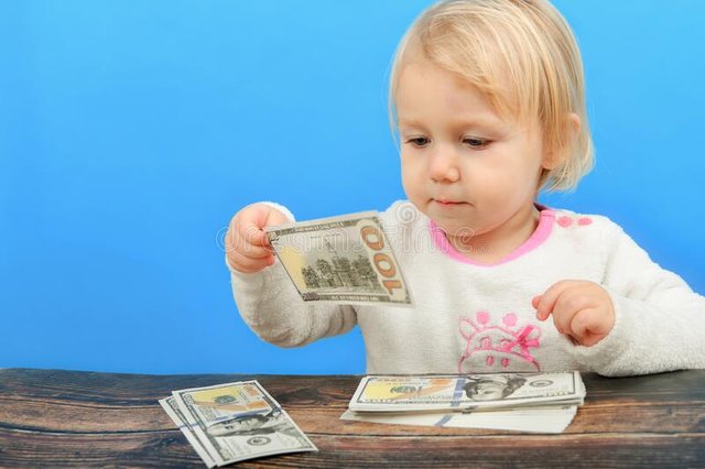 small-child-holds-hundred-dollar-bill-his-hands-looks-carefully-215970133.jpg