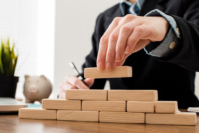 front-view-businessman-with-wooden-building-blocks_23-2148780640.jpg