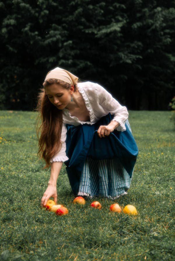 free-photo-of-woman-in-traditional-peasant-clothing-picking-apples-from-grass.jpeg