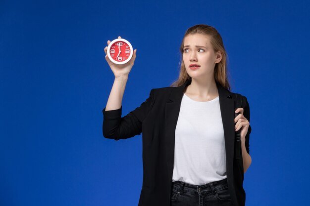 front-view-female-student-black-jacket-wearing-backpack-holding-clocks-blue-wall-school-college-university-lessons_140725-43290.jpg