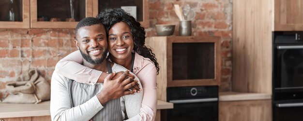 grateful-black-woman-hugging-her-husband-preparing-healthy-lunch-kitchen-empty-space_922936-57685.jpg