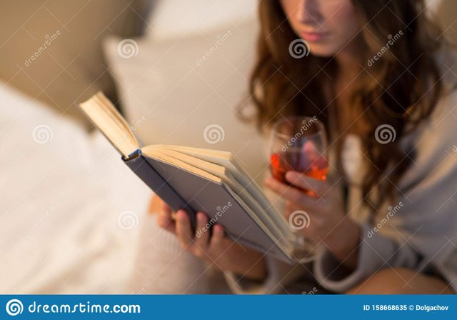 christmas-leisure-comfort-concept-close-up-young-woman-reading-book-drinking-rose-wine-glass-home-close-up-158668635.jpg