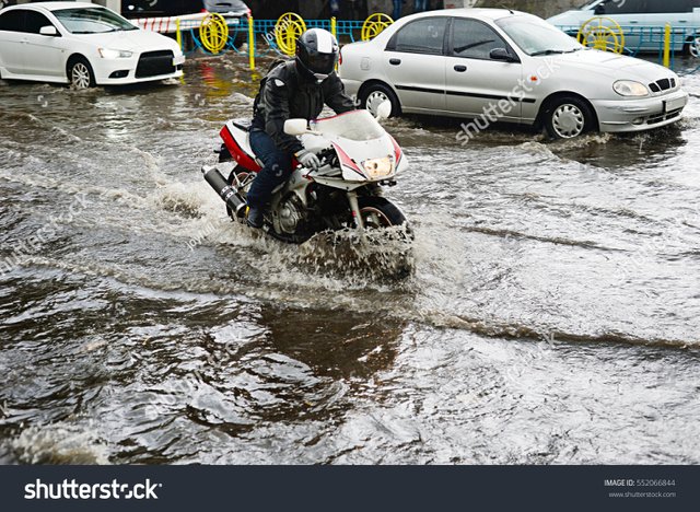 stock-photo-motorcycle-and-cars-on-flooded-road-during-the-heavy-rain-552066844.jpg