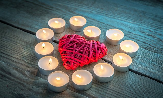 heart-with-burning-candles-on-the-wooden-backgroun-PATSWZD.jpg