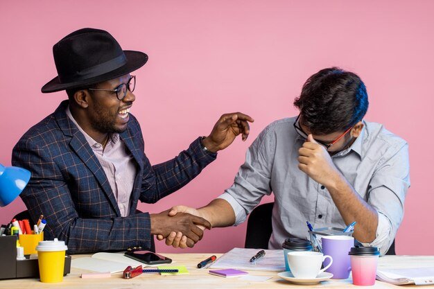 two-colleagues-working-together-discussing-new-project-making-financial-report-holding-pens-sitting-office-desk-wearing-formal-wear-glasses-drinking-coffee-business-job-concept_248459-643.jpg