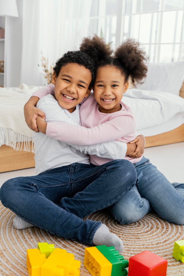 front-view-two-smiley-siblings-embracing-each-other-home.jpg