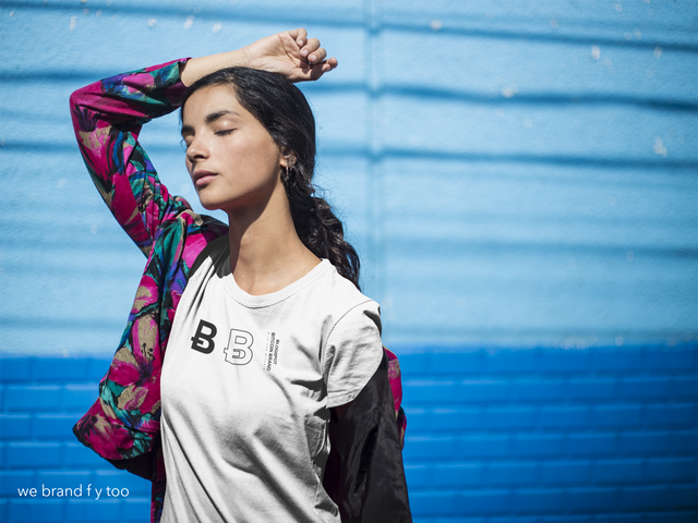 girl-wearing-a-round-neck-tee-mockup-while-posing-against-a-blue-wall-a18435.png