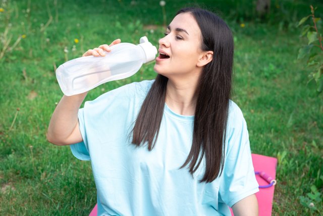 young-woman-drinking-water-after-exercising-outdoors.jpg