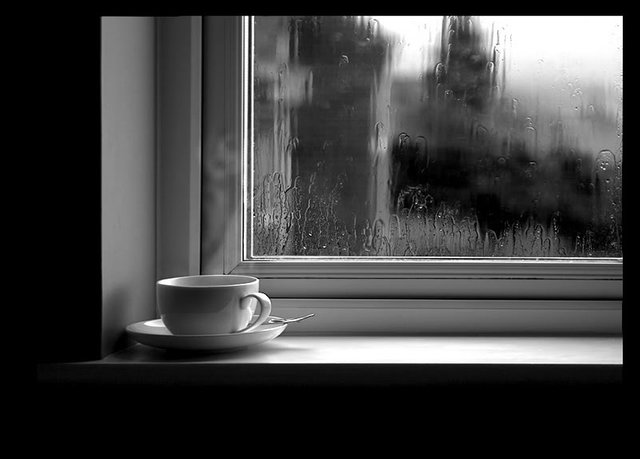 rainy days cup of tea warminside black and white photograph.jpg