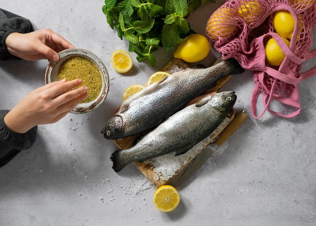 top-view-hands-cooking-raw-trout_23-2150408590.jpg