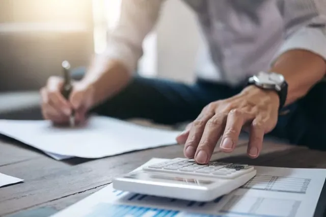 man-doing-finance-paperwork-with-calculator.jpg