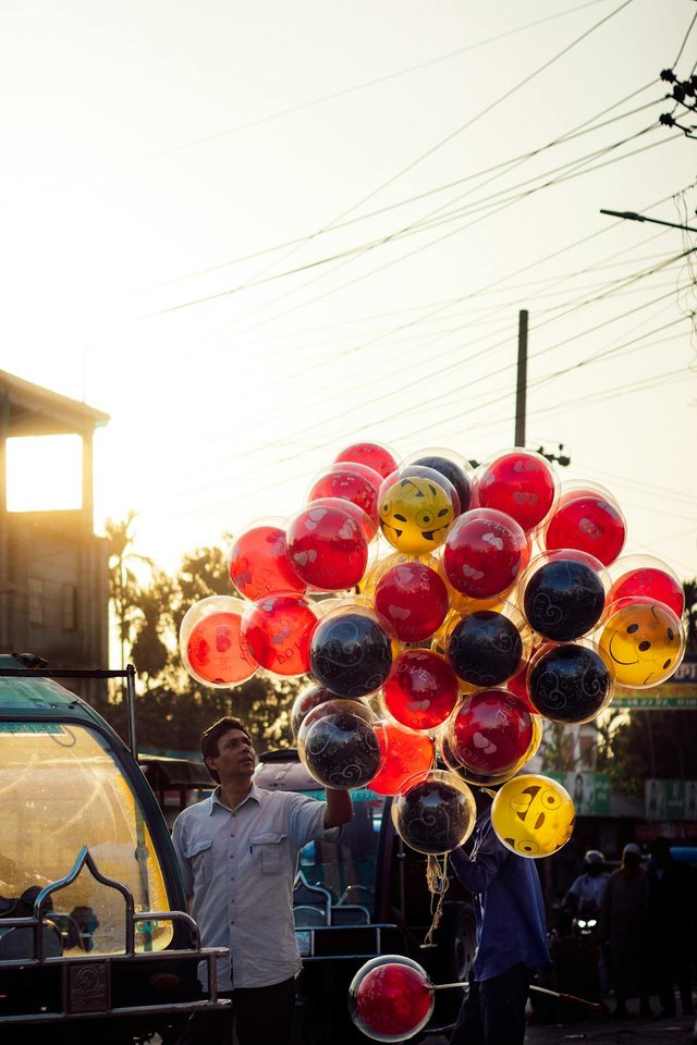 free-photo-of-a-man-is-holding-a-bunch-of-balloons-in-the-air.jpeg