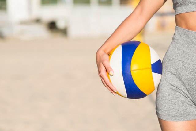 front-view-of-female-volleyball-player-on-the-beach-holding-ball-with-copy-space.jpg