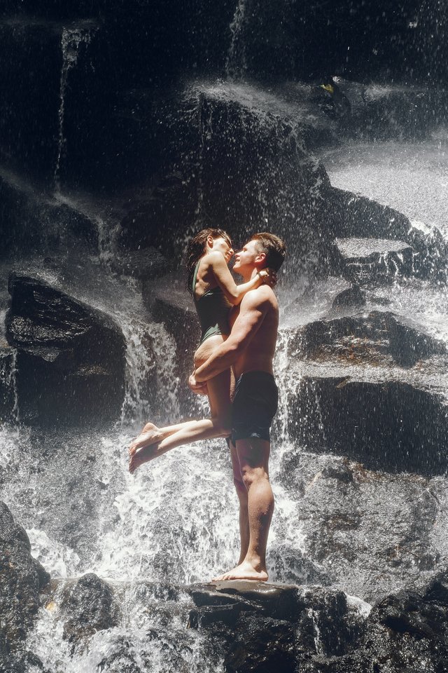 couple-kissing-on-rock-under-waterfall-4172846.jpg