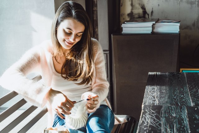 la-ragazza-lavora-a-maglia-in-un-caffe.jpg