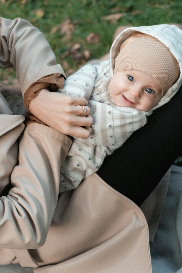 free-photo-of-bayi-tersenyum-dengan-topi-rajutan-bersama-orang-tua-di-luar-ruangan.jpeg