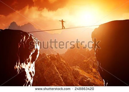 stock-photo-man-walking-and-balancing-on-rope-over-precipice-in-mountains-at-sunset-concept-of-business-risk-248863420.jpg