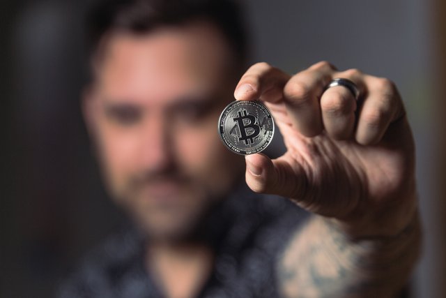 person-holding-silver-bitcoin-coin-1447418.jpg