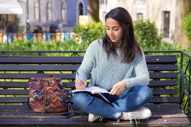 serious-woman-making-notes-sitting-bench-outdoors1.jpg