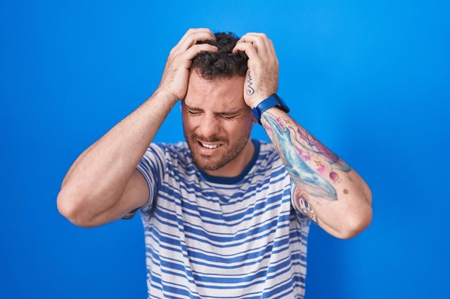 young-hispanic-man-standing-blue-background-suffering-from-headache-desperate-stressed-because-pain-migraine-hands-head_839833-1984.jpg