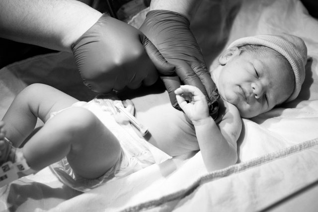 greyscale-closeup-doctor-checking-newborn-child-lights-hospital.jpg