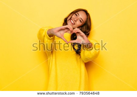 stock-photo-smiling-young-girl-in-yellow-sweater-showing-heart-with-two-hands-love-sign-isolated-over-yellow-793564648.jpg