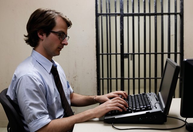 pikaso_texttoimage_A-Journalist-Typing-on-a-pc-keyboard-Behind-Jail-B.jpeg