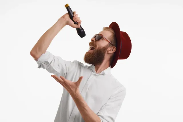 people-music-fun-show-entertainment-concept-emotional-handsome-stylish-red-haired-pop-artist-with-thick-beard-singing-microphone-wearing-red-round-hat-trendy-shades_343059-2930.webp