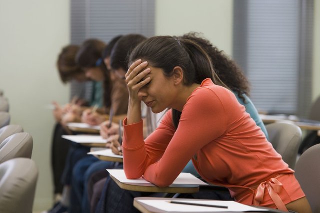 students-taking-written-examination--woman-holding-hand-to-head-200446112-007-59dfd071685fbe0011ae04ee.jpg