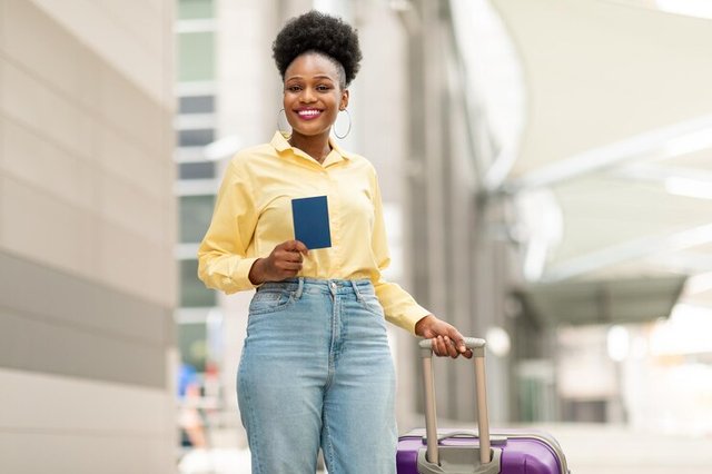 happy-black-woman-with-suitcase-holding-passport-airport_116547-51029.jpg