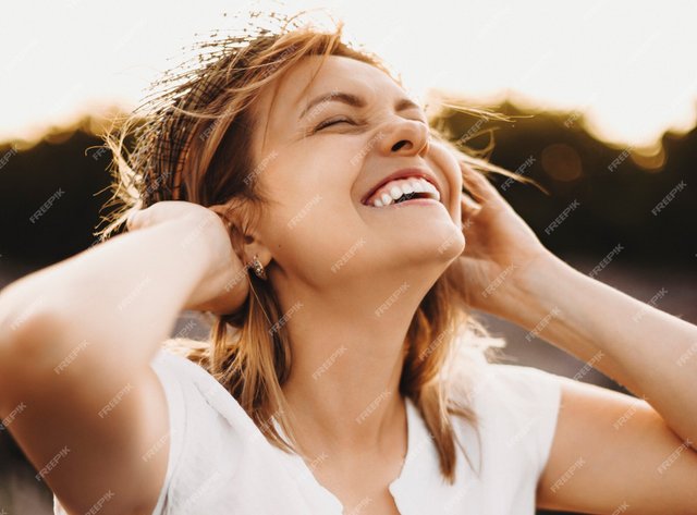 cerrar-retrato-bella-mujer-caucasica-riendo-ojos-cerrados-mientras-sostiene-su-corona-lavanda-contra-puesta-sol_129180-2742.jpg