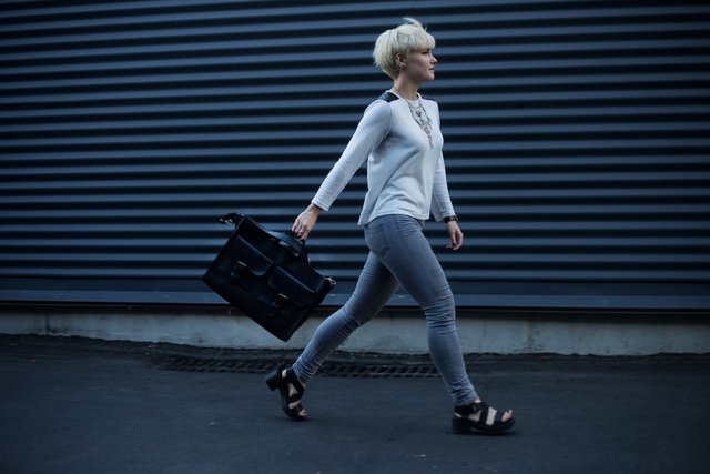 woman-holding-black-leather-handbag-walking-on-the-street-1231062.jpg