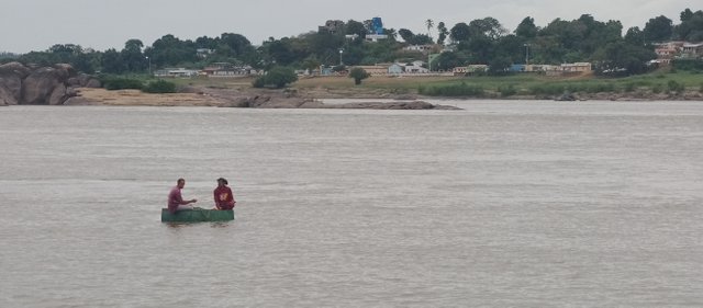 Dos pescadores y al fondo la ciudad vecina