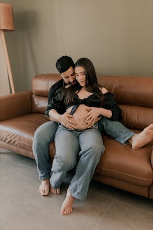 free-photo-of-a-pregnant-couple-sitting-on-a-couch-in-their-living-room.jpeg