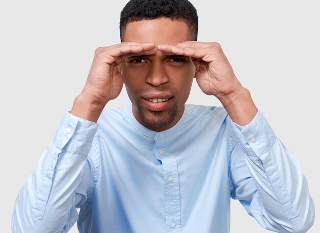 closeup-studio-portrait-young-african-american-man-posing-advertisement-wearing-blue-shirt-looking-away-with-hands-forehead-isolated-white-wall-people-emotion_616427-4707.jpg