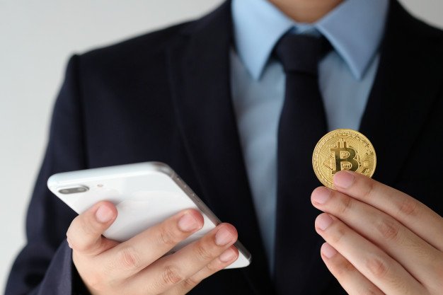 businessman-hand-holding-bitcoin-and-using-smartphone-over-white-background_7190-2309.jpg