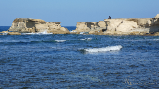 Lone figure on rocks.png