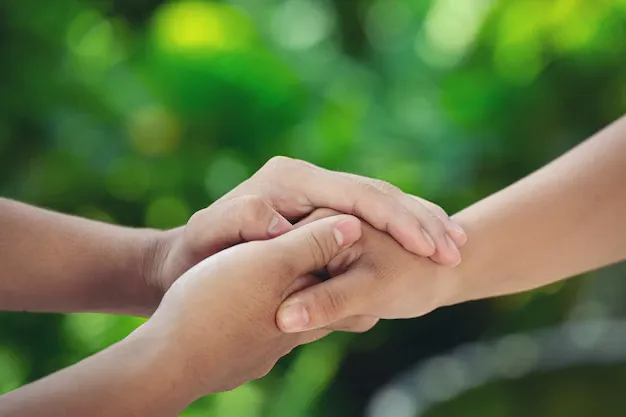 couple-holding-hands-green-meadow_1150-26188.webp