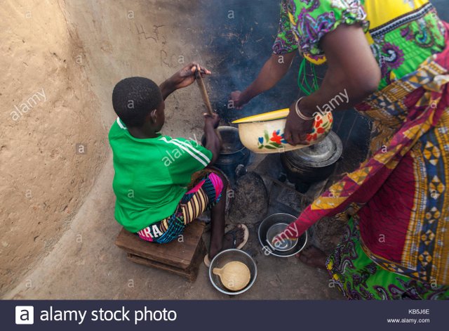 a-young-girl-helping-her-mother-cook-at-their-home-in-tinguri-ghana-KB5J6E.jpg