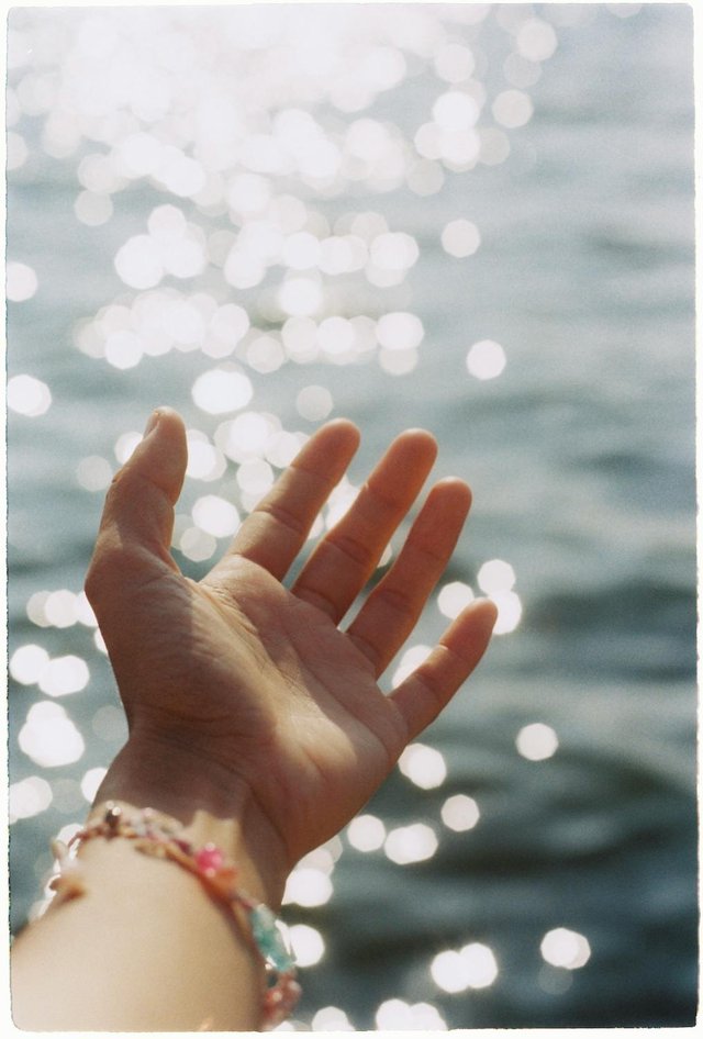 free-photo-of-open-hand-reaching-towards-sparkling-water-surface.jpeg