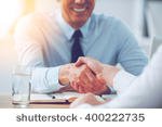 stock-photo-good-deal-close-up-of-two-business-people-shaking-hands-while-sitting-at-the-working-place-400222735.jpg