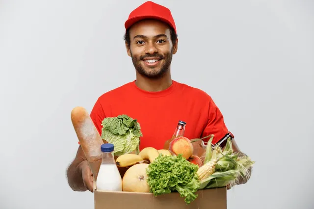delivery-concept-handsome-african-american-delivery-man-carrying-package-box-grocery-food-drink-from-store-isolated-grey-studio-background-copy-space_1258-1229.webp