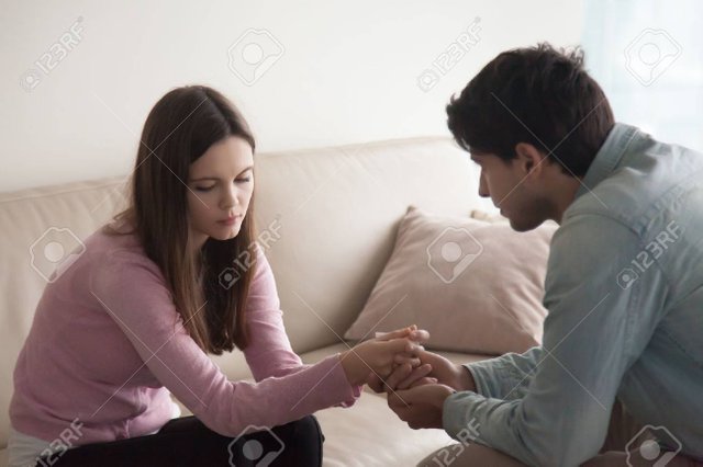 76070338-sad-couple-sitting-opposite-one-another-man-holding-hands-of-a-woman-loving-husband-comforting-troub.jpg