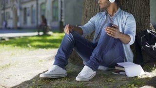 videoblocks-mixed-young-man-listening-to-music-in-headphones-under-tree-smiling-enjoyment_scxhmmu4b_thumbnail-small10.jpg