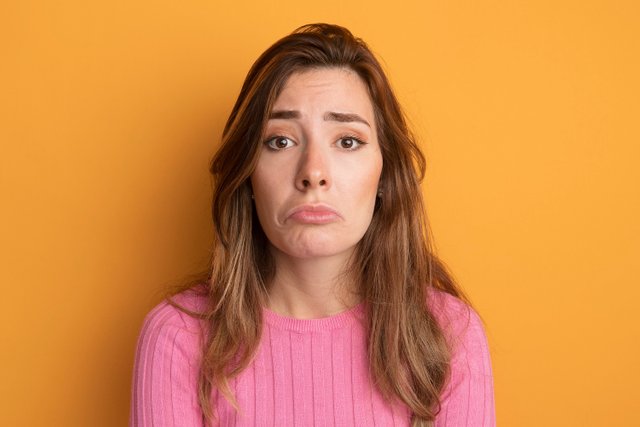 upset-young-beautiful-woman-pink-top-looking-camera-with-sad-expression-pursing-lips.jpg