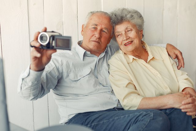elegant-old-couple-sitting-home-using-camera.jpg