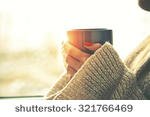 stock-photo-hands-holding-hot-cup-of-coffee-or-tea-in-morning-sunlight-321766469.jpg