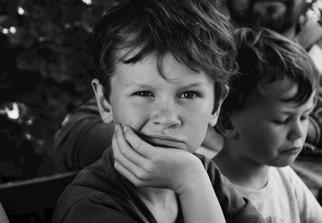 free-photo-of-freckled-boy-with-head-rested-on-his-hand-sitting-next-to-his-little-brother-and-father-on-a-bench.jpeg