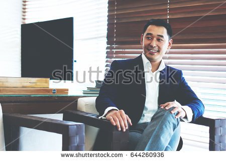 stock-photo-cheerful-asian-businessman-in-formal-wear-is-smiling-for-someone-while-is-sitting-in-modern-644260936.jpg