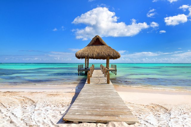 Tropical-white-sandy-beach.-Palm-leaf-roofed-wooden-pier-with-gazebo-on-the-beach.-Punta-Cana-Dominican-Republic-shutterstock_583369816.jpg